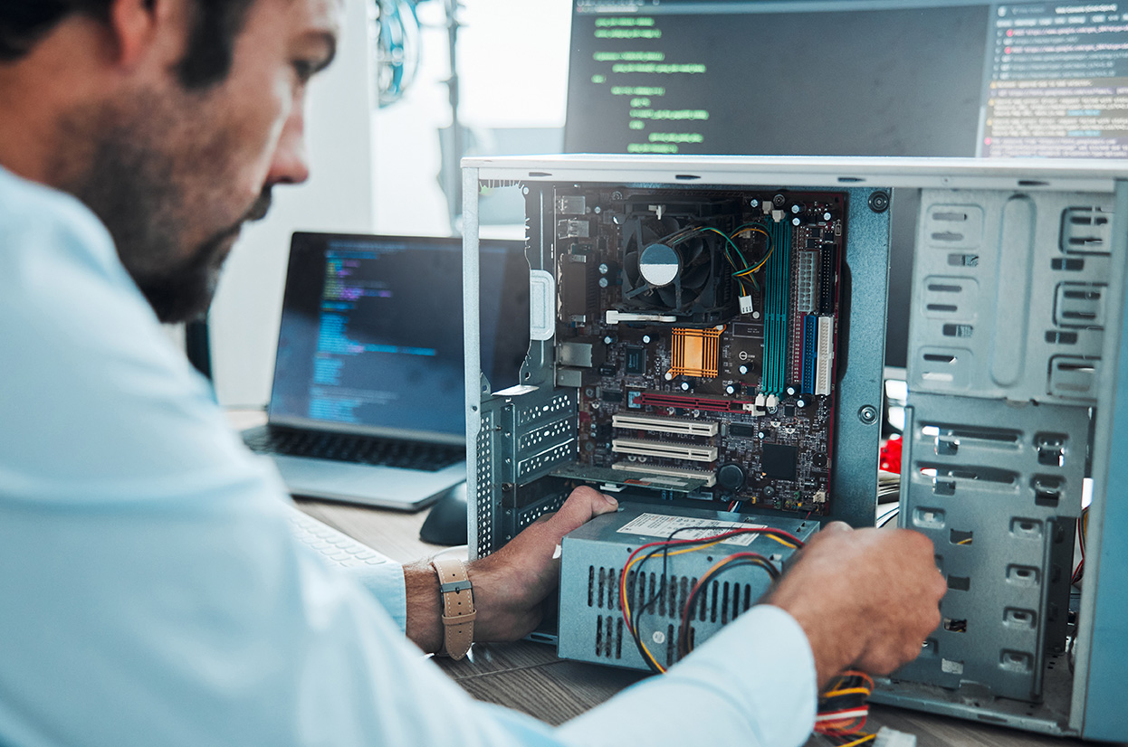 It technician, engineer and computer hardware with a man working to fix or maintenance technology. Hands of expert IT person in office data center for system repair, engineering or motherboard update